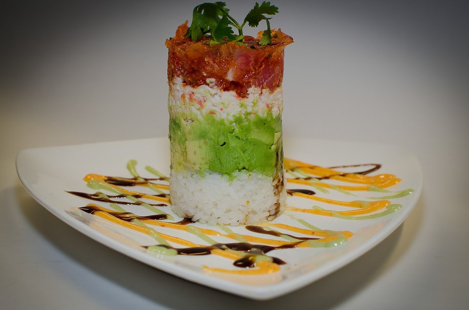 Colorful plates of sushi and spring rolls.